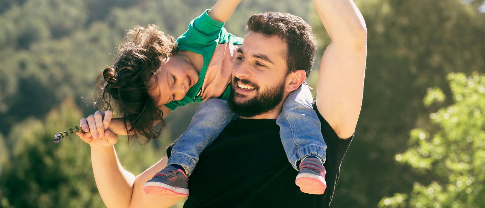 Vater trägt Kind auf den Schultern