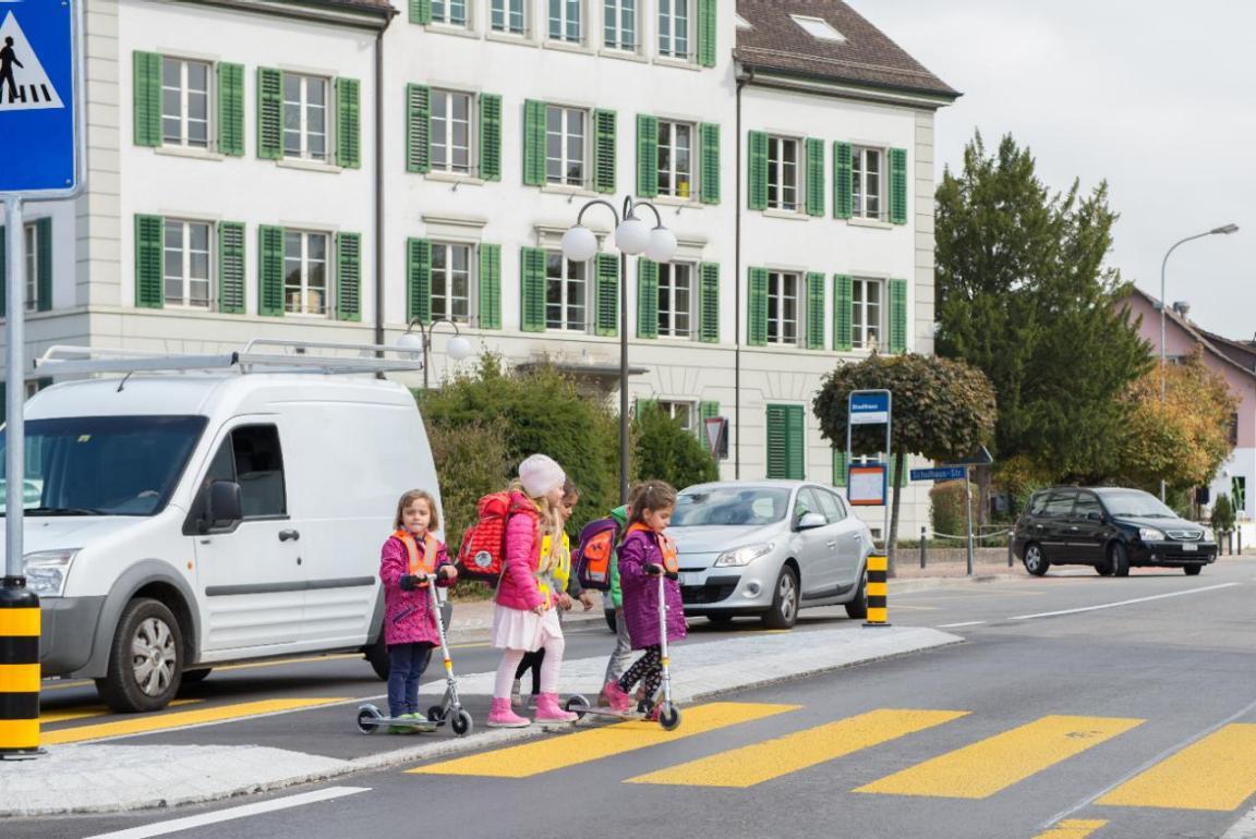 Schulkinder überqueren einen Fussgängerstreifen.