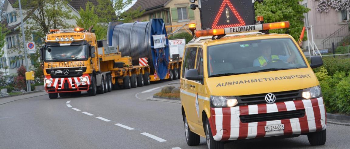 Ein privater Ausnahmetransportbegleiter fährt einem Schwertransport voran. 